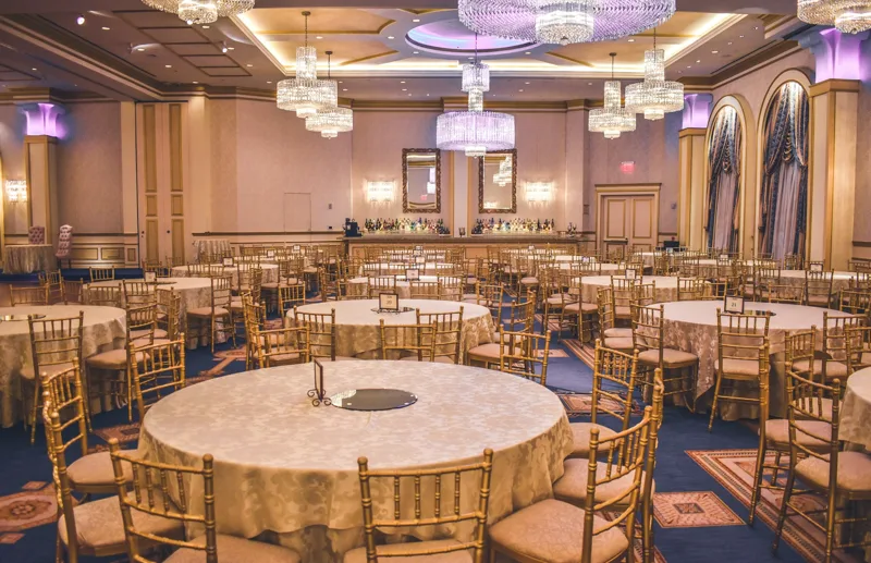 Banquet tables arranged in an ornate ballroom