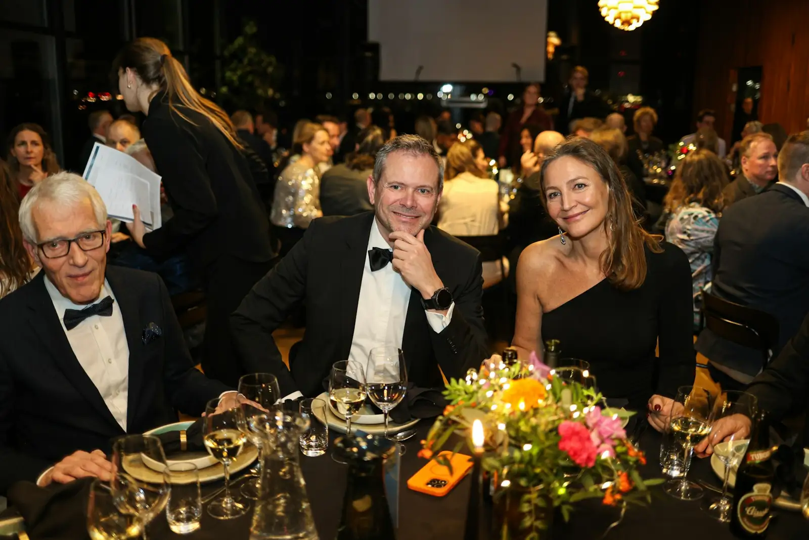 Three people at a formal dinner event