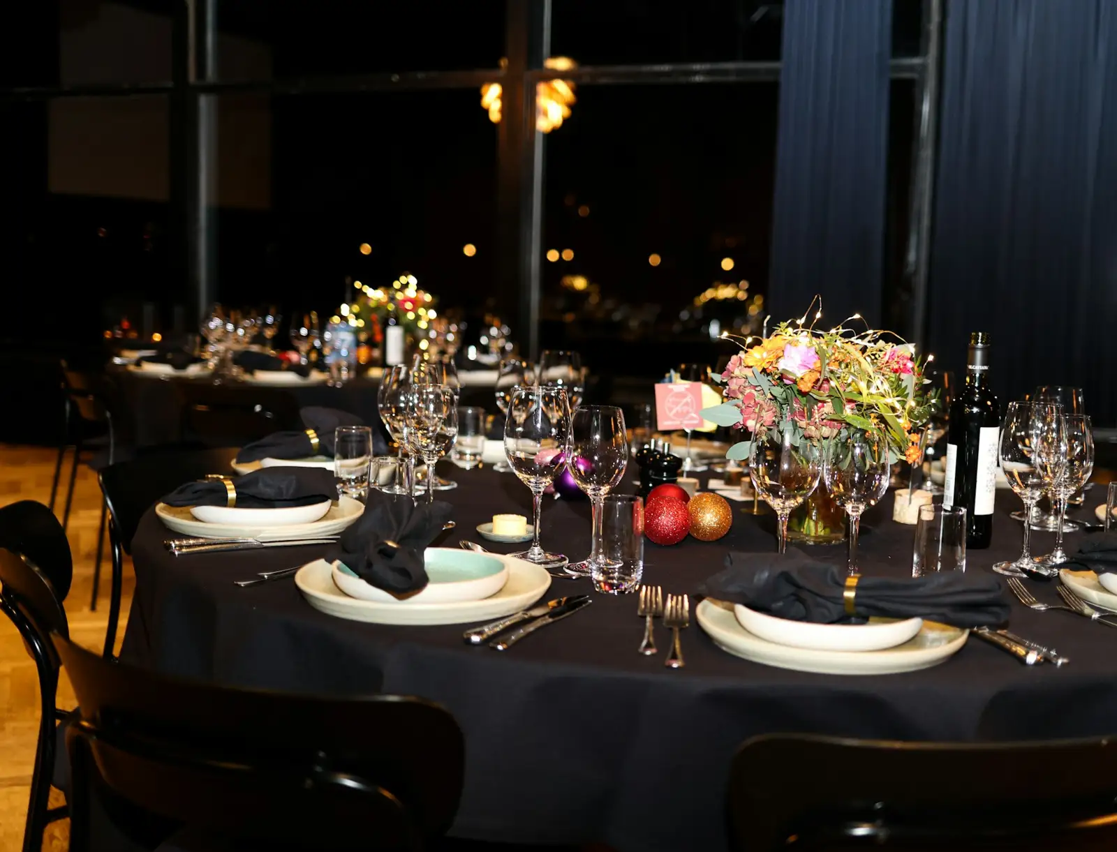 A formal dinner table setting with black tablecloth