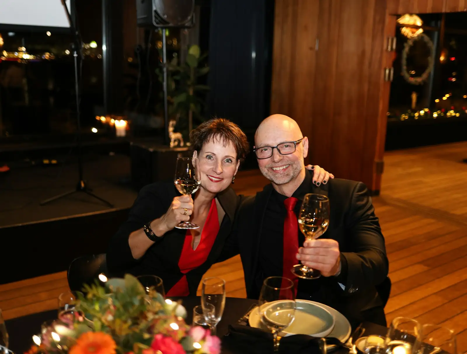 Couple raising wine glasses at a formal dinner
