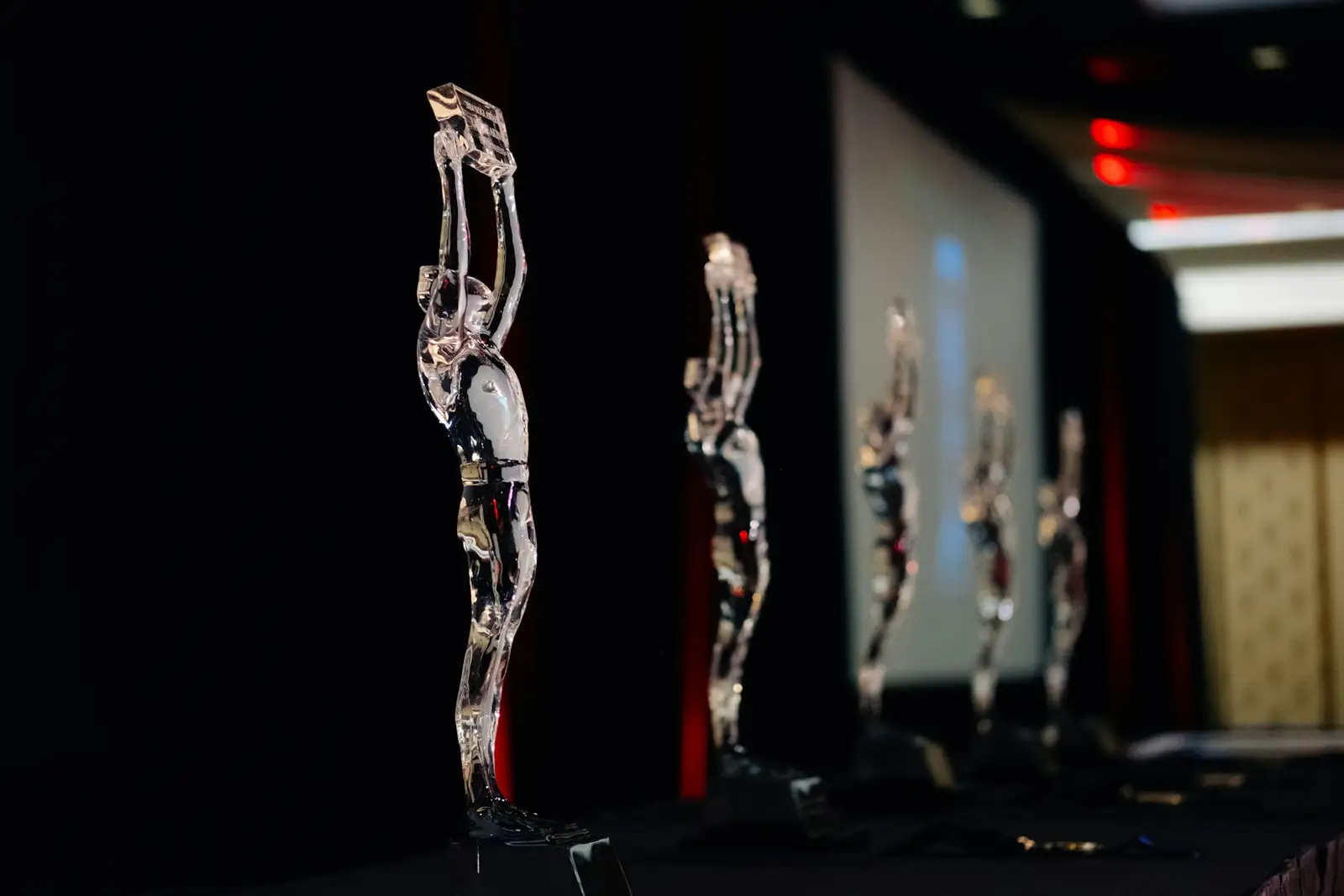 Several clear statuettes stand in a row