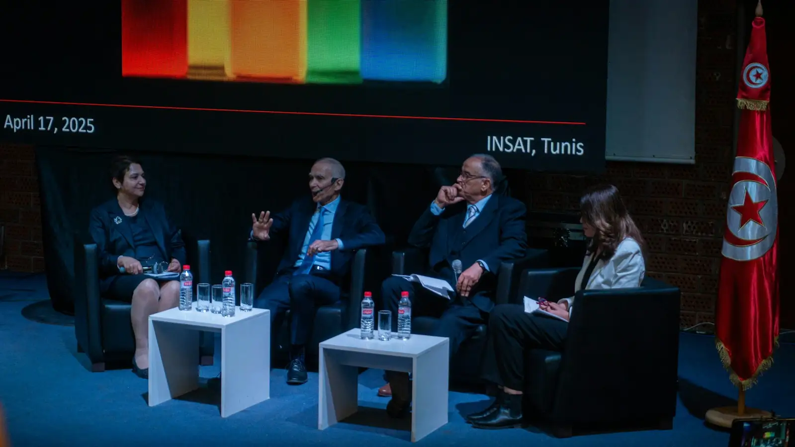 Four people sit on a stage at a panel discussion