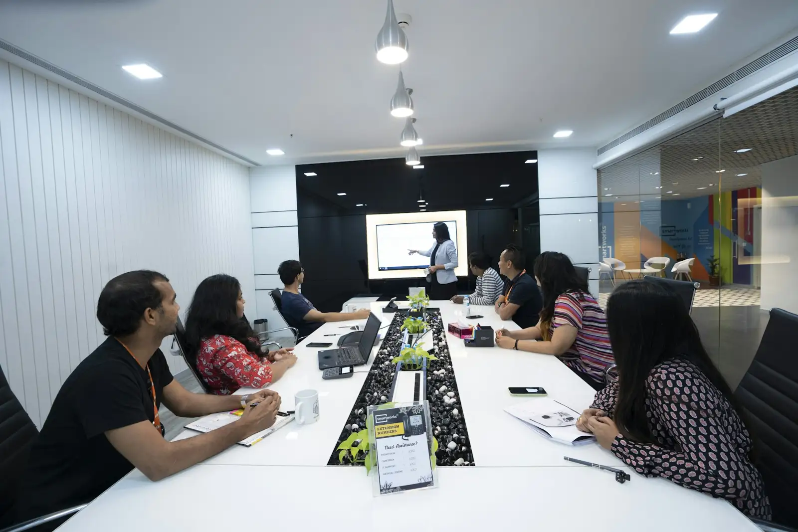 people sitting at the table looking to another person standing in front of them
