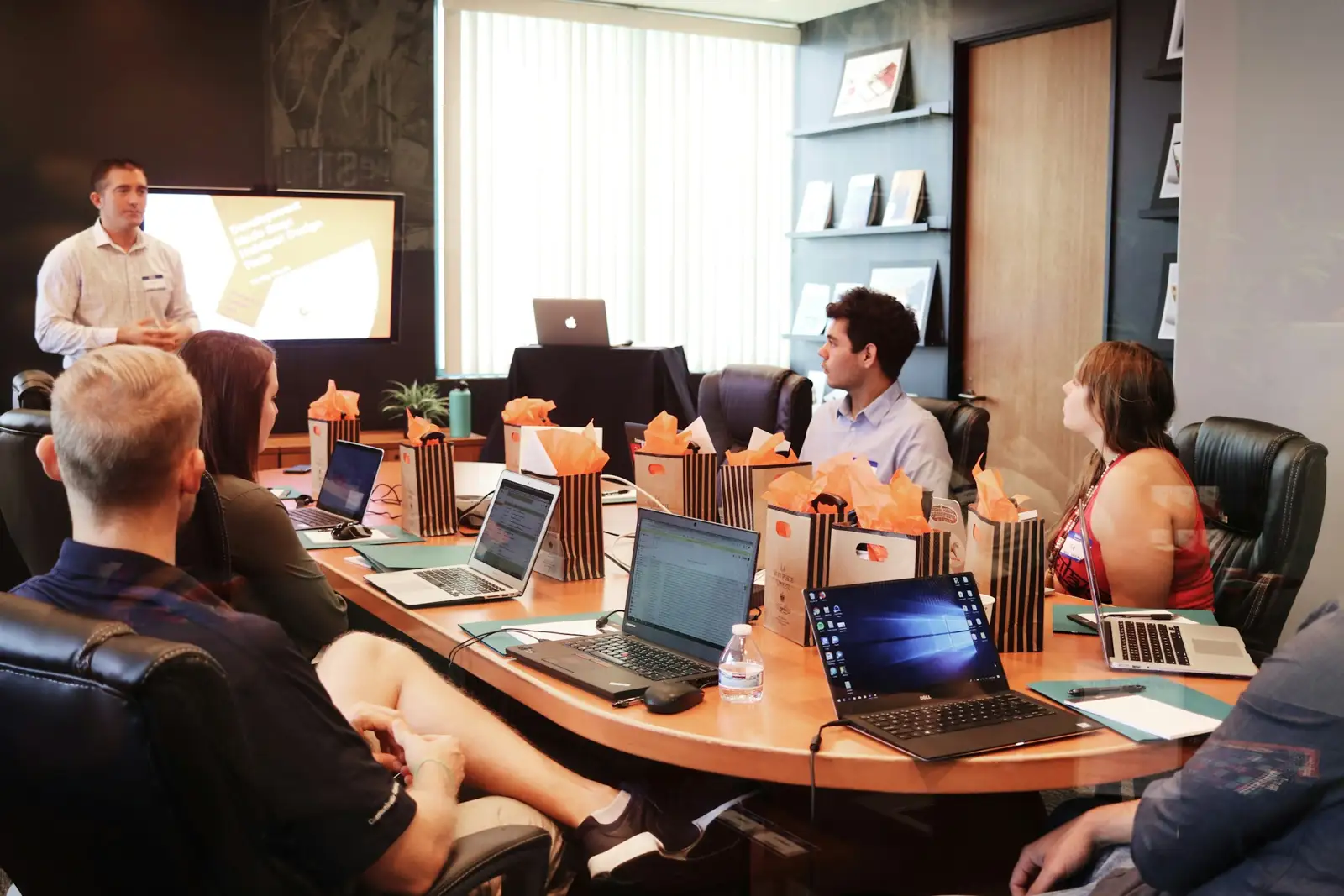 Team members collaborating around laptops in an office