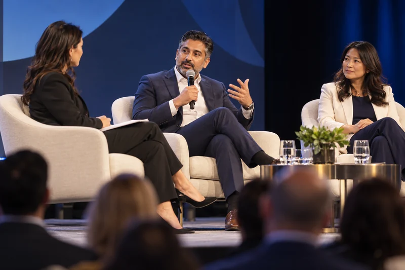 Moderator and business leaders in a panel discussion on stage