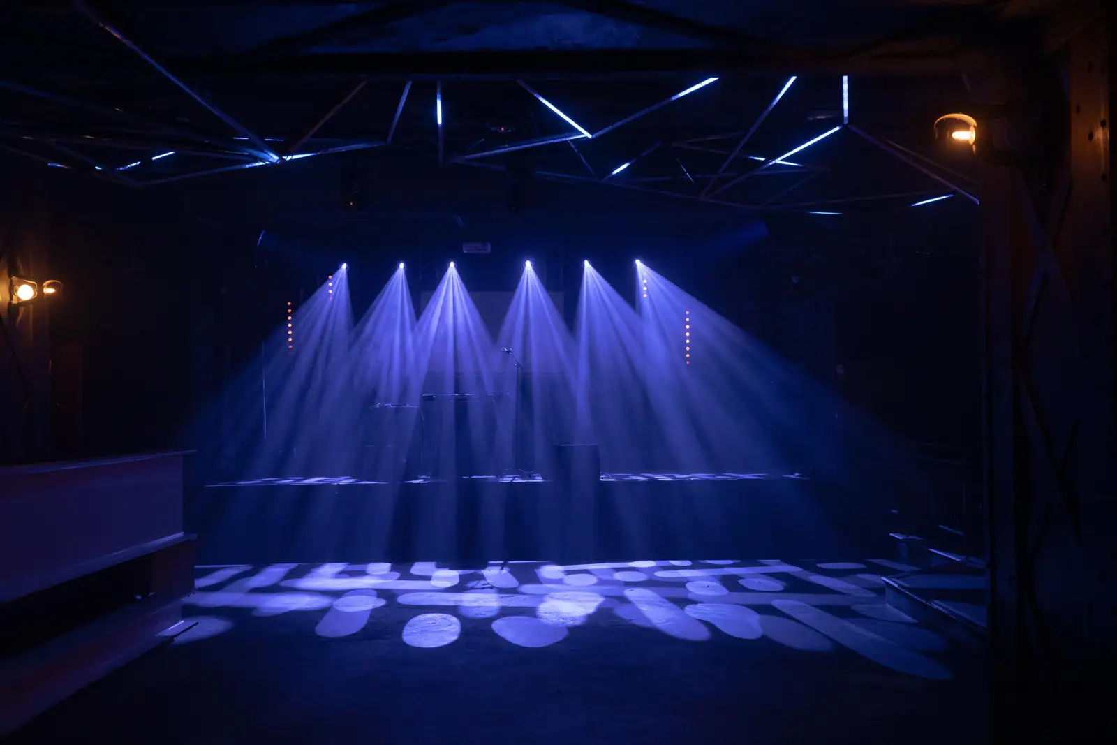 Blue-lit stage inside a concert venue