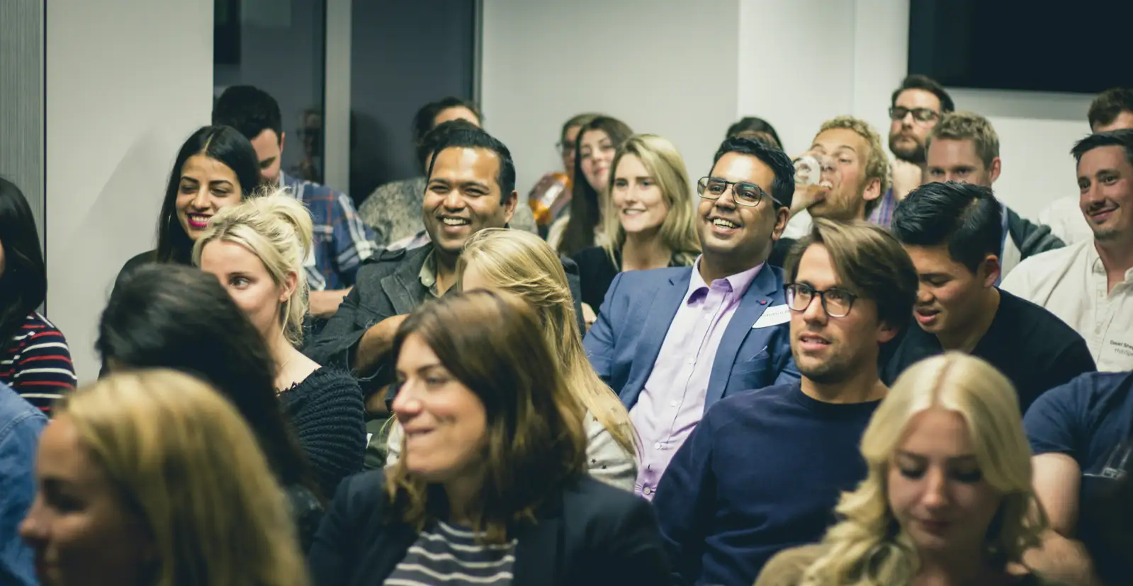 Audience members listening during a company gathering