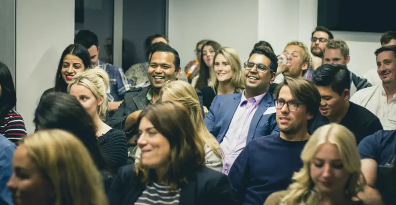 Audience members listening during a company gathering