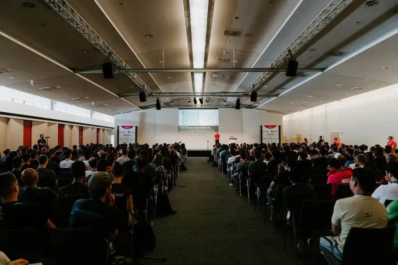 Delegates seated for a convention session in a bright hall
