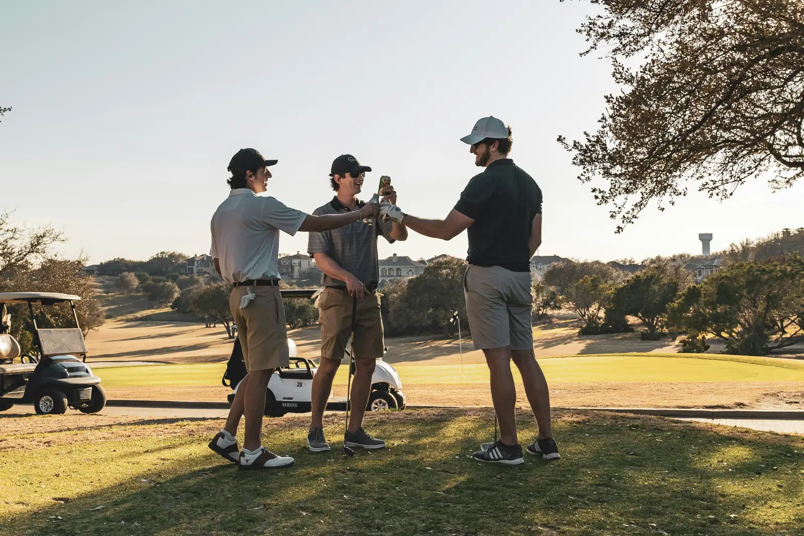 Golfers greeting one another beside golf carts on a course