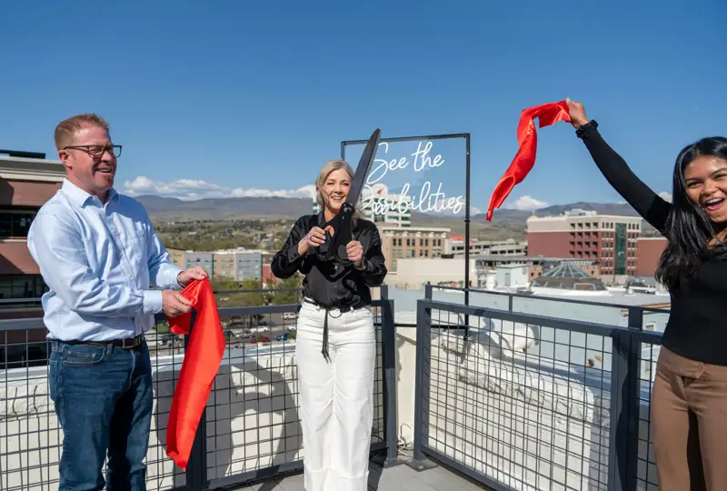 Guests celebrating a ribbon cutting on an outdoor terrace