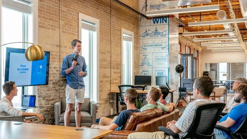 Presenter speaking to seated business guests in a meeting space