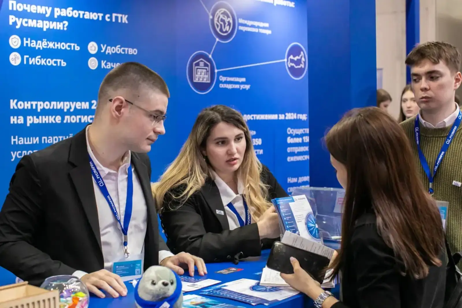 Exhibitors speaking with visitors at a branded trade show booth