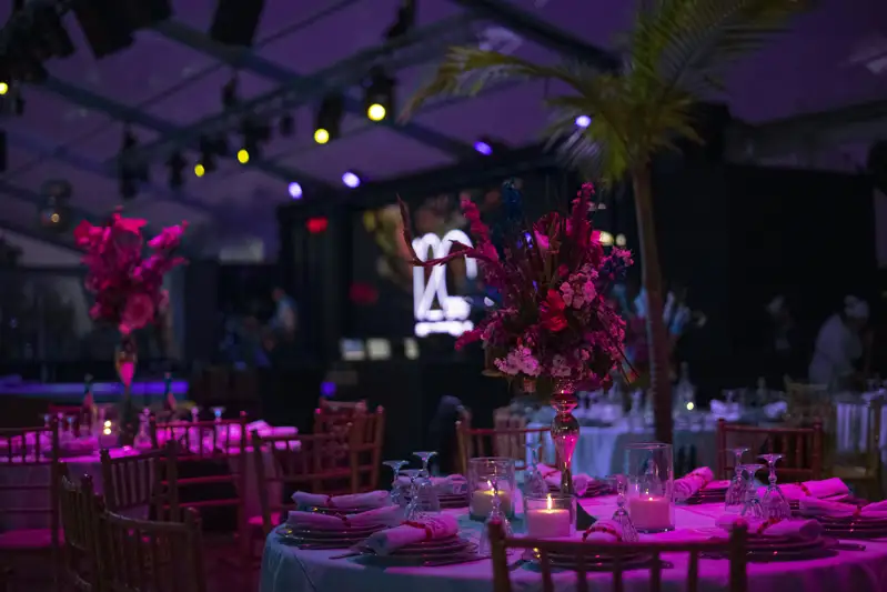 Floral centrepieces and dramatic lighting in a decorated event space