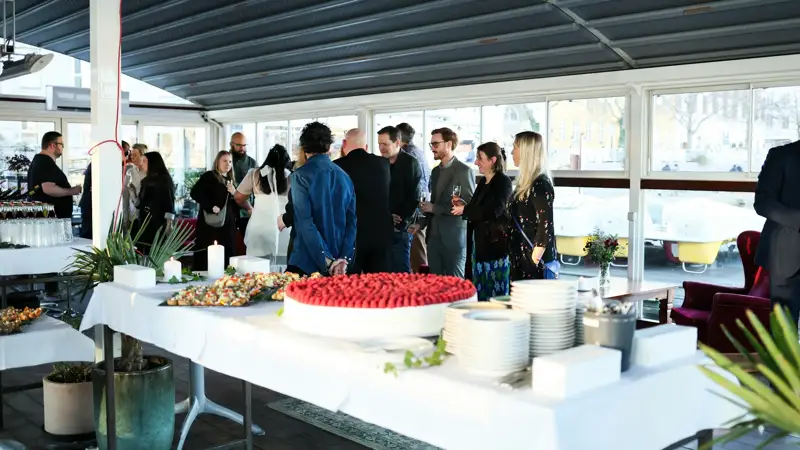 People mingling around a buffet table at an event