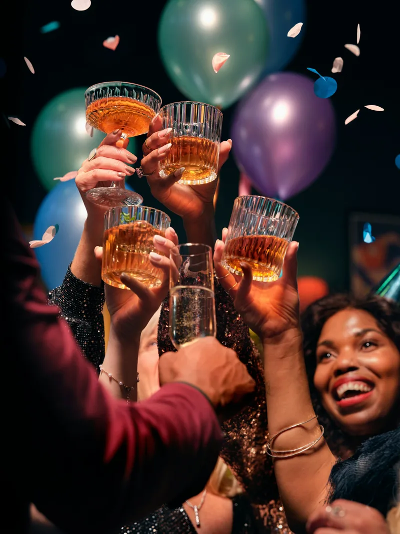Guests raising a toast with confetti and balloons